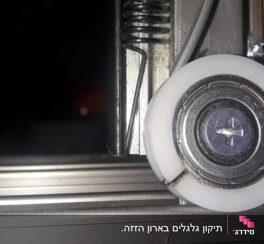 גלגלת מתכת עם קפיץ על מסילה